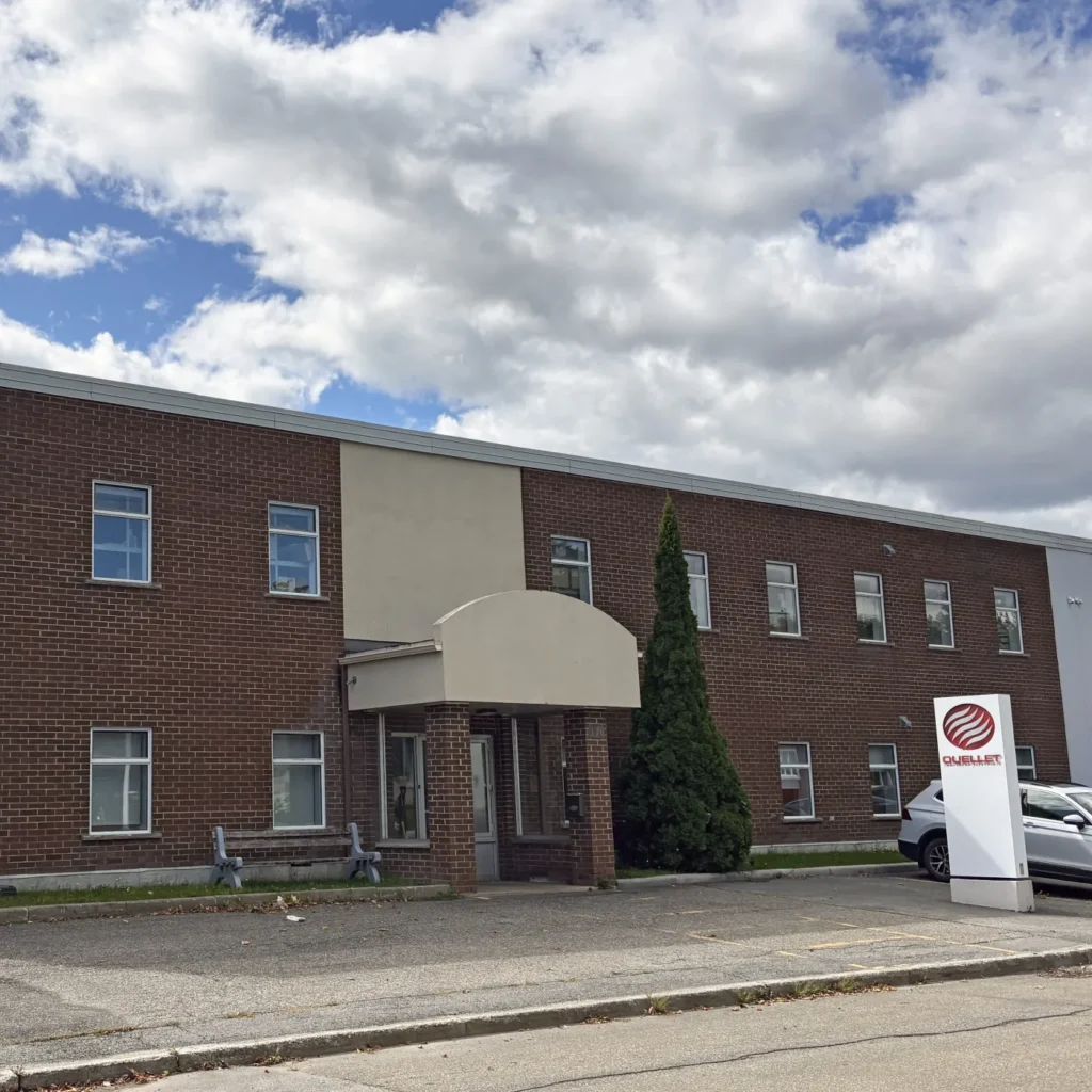 Façade en brique de l’usine Ouellet à Montmagny, avec son enseigne à l’entrée
