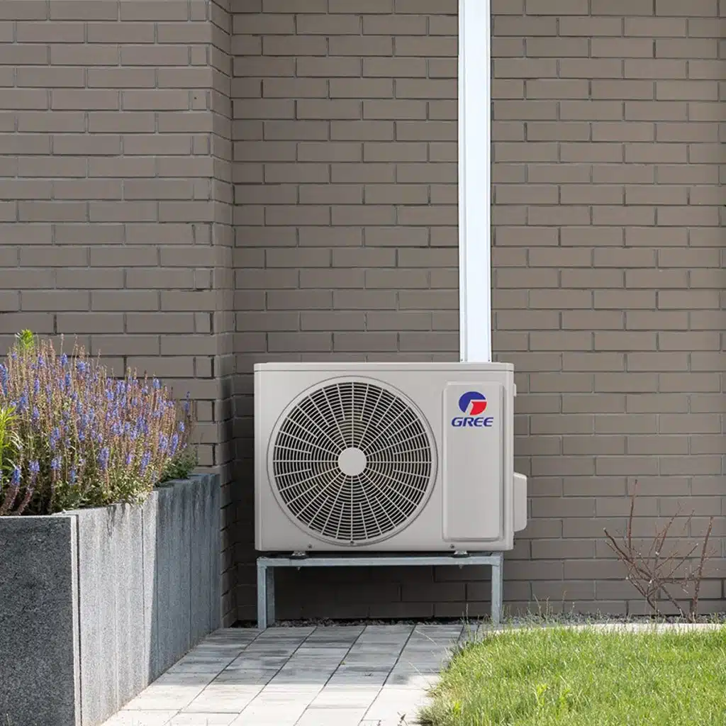 Thermopompe extérieure installée contre un mur de brique