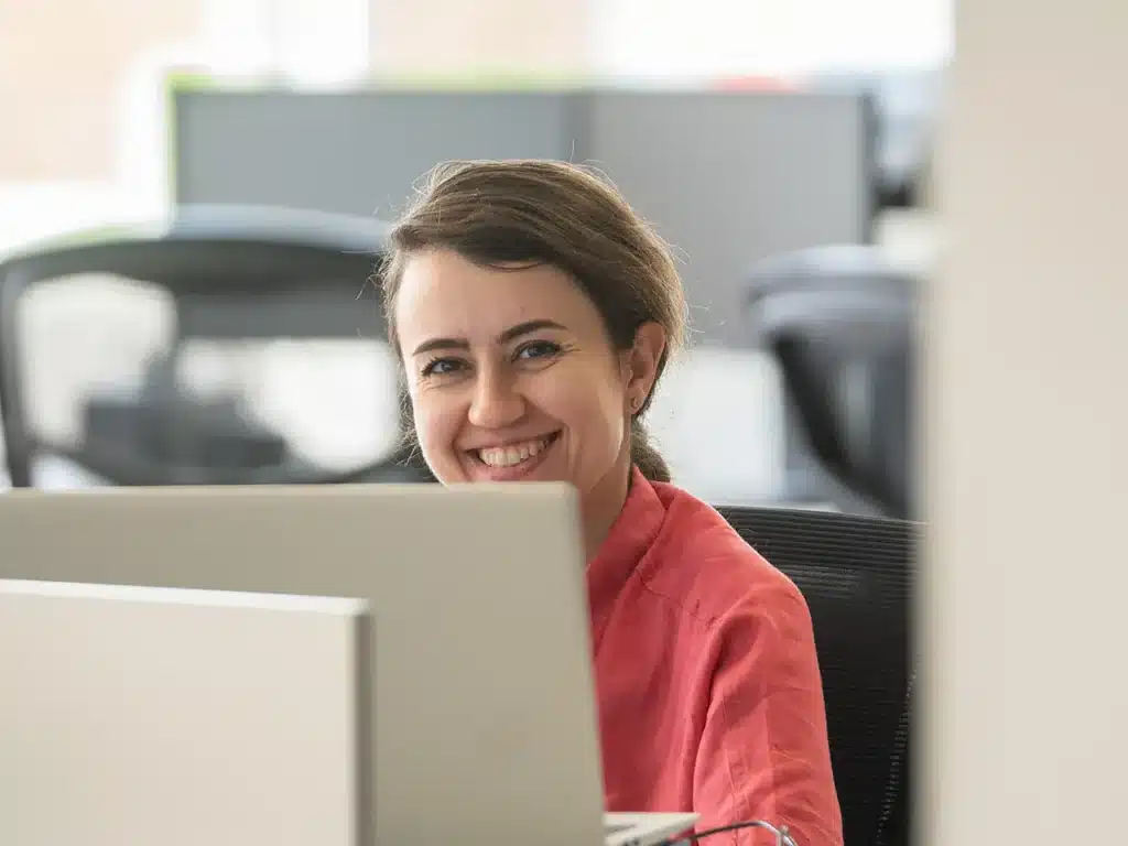 Employée souriante à son poste de travail dans les bureaux d'Innovair