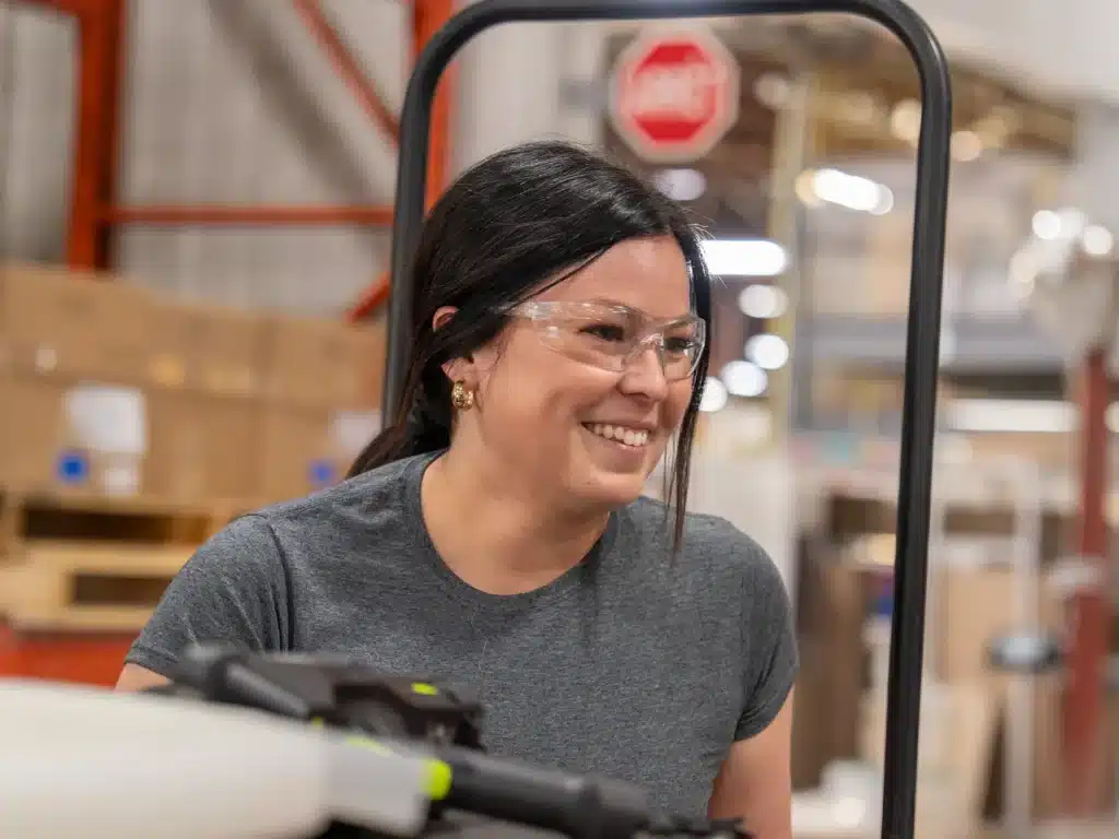 Smiling Innovair employee wearing safety glasses in a warehouse