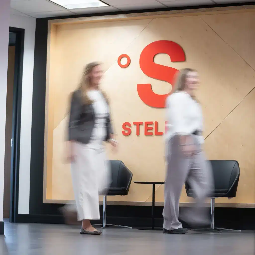 Deux collègues de Stelpro marchent dans l’aire d’accueil, devant le logo de l’entreprise